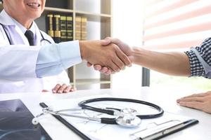 Doctor shaking hands with patient  photo