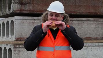 Trabajador comiendo hamburguesas en el sitio de construcción