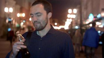 Young man drinking coke at night city