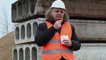 Trabajador comiendo papas fritas en el sitio de construcción video