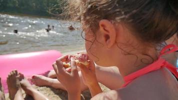 tonåring flicka äter smörgås på strand semester semester slow motion video