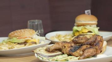 dishes of fast food: hamburgers, chicken, French fries, salad