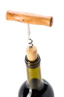 Bottle of wine with corkscrew on white background