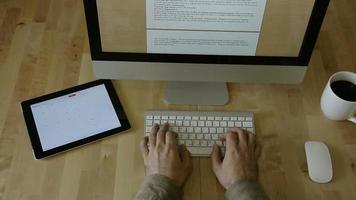 typen op houten bureau met tablet en laptop, zonder logo