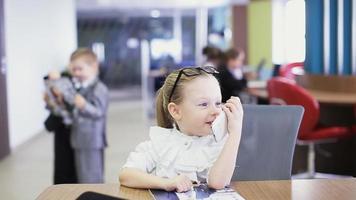 school children in classroom talking by phone video