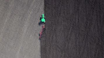 Aerial: Tractor plowing the soil. Top view. video