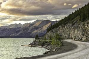 Curved asphalt road in high mountains of Alaska