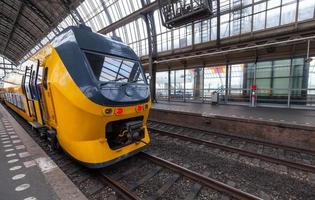 Yellow train stands on the central railroad station in Amsterdam
