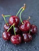 Ripe juicy cherries with water drops on dark background