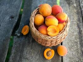 apricots in a basket on wooden background photo