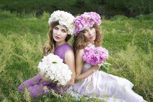 Two young girls with rose peony wreath photo