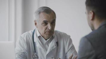 Senior doctor consults patient video