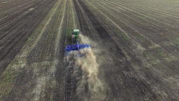 Aerial: Tractor plowing the soil on sunset