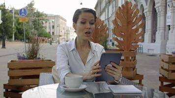 parler à ma chérie. Jeune femme séduisante parlant par skype sur une nouvelle tablette video