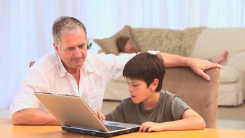 grootvader en zijn kleinzoon met behulp van een laptop video