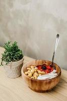 Sliced berries and cashews in wooden bowl photo