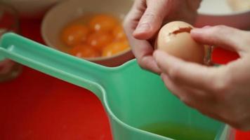 assando bolo. mãos separando o ovo na tigela