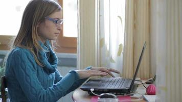 glad ung vacker kvinna som använder bärbara datorer, inomhus video