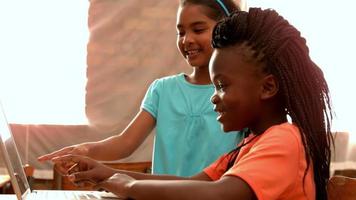 Little girls using laptop in classroom