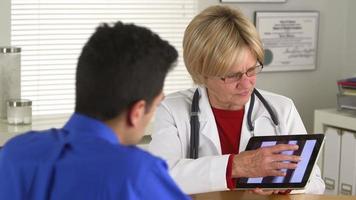 Doctor hablando con paciente hispano sobre radiografías video