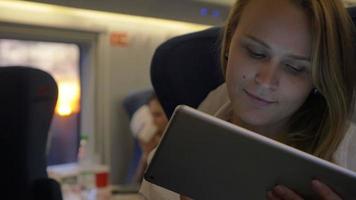 vrouw reist per trein met tablet pc