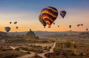 Aerial shot of hot air balloons floating in the sky at dusk