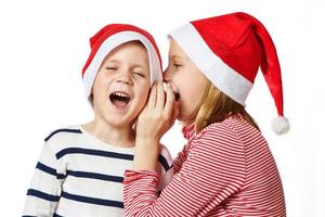 Girl and little boy in Santa Claus hat photo