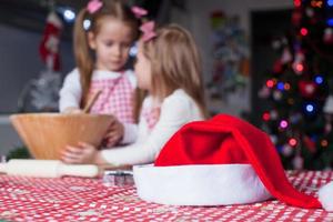 Santa Hat background of two little girl baking christmas cookies photo