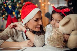 Happy mother with her daughter in santa claus hats