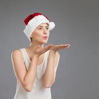 Young woman in santa's hat sending a kiss