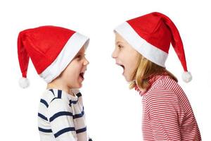 Girl and little boy in Santa Claus hat photo