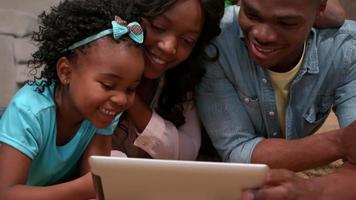 família usando tablet pc junta no chão video