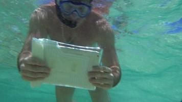 Mann, der Korallenriff mit Tablette PC schießt