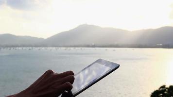 Man using tablet computer outdoor. video
