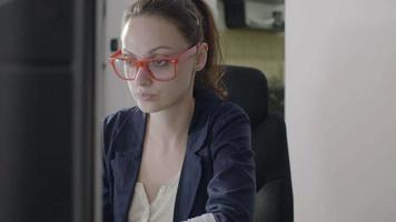 Businesswoman sitting at desk in high tech startup office working on computer video
