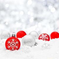 Christmas baubles in snow with silver background