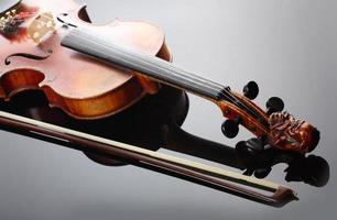 violín y arco sobre fondo oscuro foto