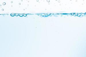 Surface of the blue water waves splash on a white background photo