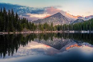 Trees reflecting in clear lake photo