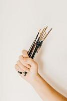 Cropped person carrying set of paintbrushes photo