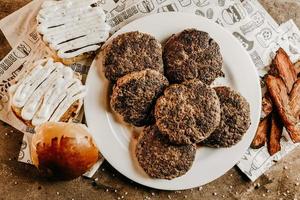 Delicious burgers and buns on table photo