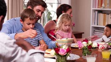 gruppo di famiglie che mangiano insieme a casa