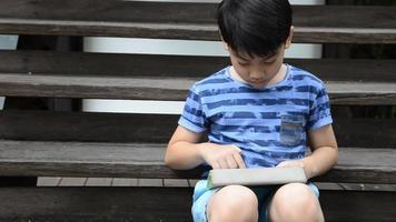 ungt asiatiskt barn som använder en digital tablett tillsammans. video