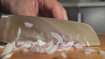 SLOW-CLOSEUP: Cook cuts an onion bulb on on a board