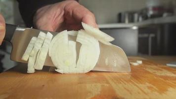 SLOW: A cook cuts an onion bulb on on a board video