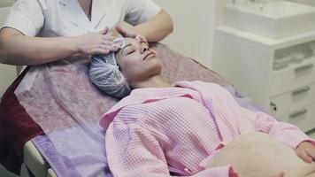 mulher afro-americana recebendo massagem facial em salão de spa video