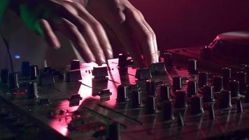 Dj hands on stylish equipment deck, touching, dancing and playing, close up, pink backlight, slow motion video