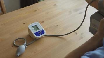 un anciano midiendo la presión arterial en casa video