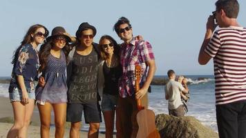 grupo de jovens tirando fotos juntos na praia