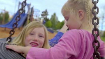 Sisters in the middle of a tire swing together video